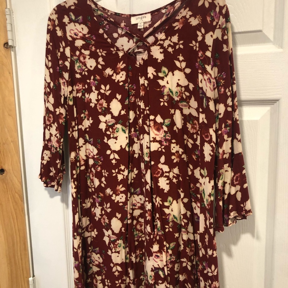 Long floral shirt with flare sleeves and cross cross on top.